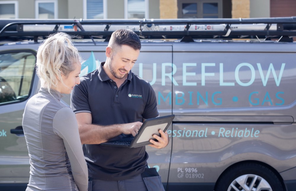 Sureflow plumber going through hot water system pricing with a customer
